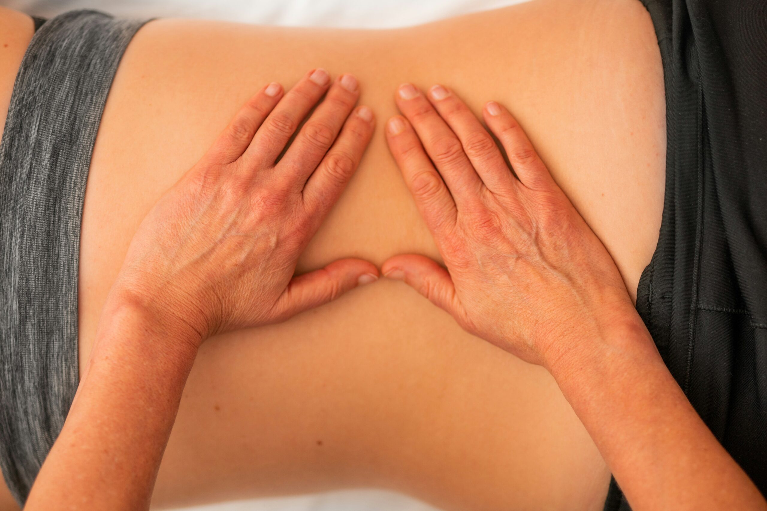 Image of two hands on woman's waist and lower back