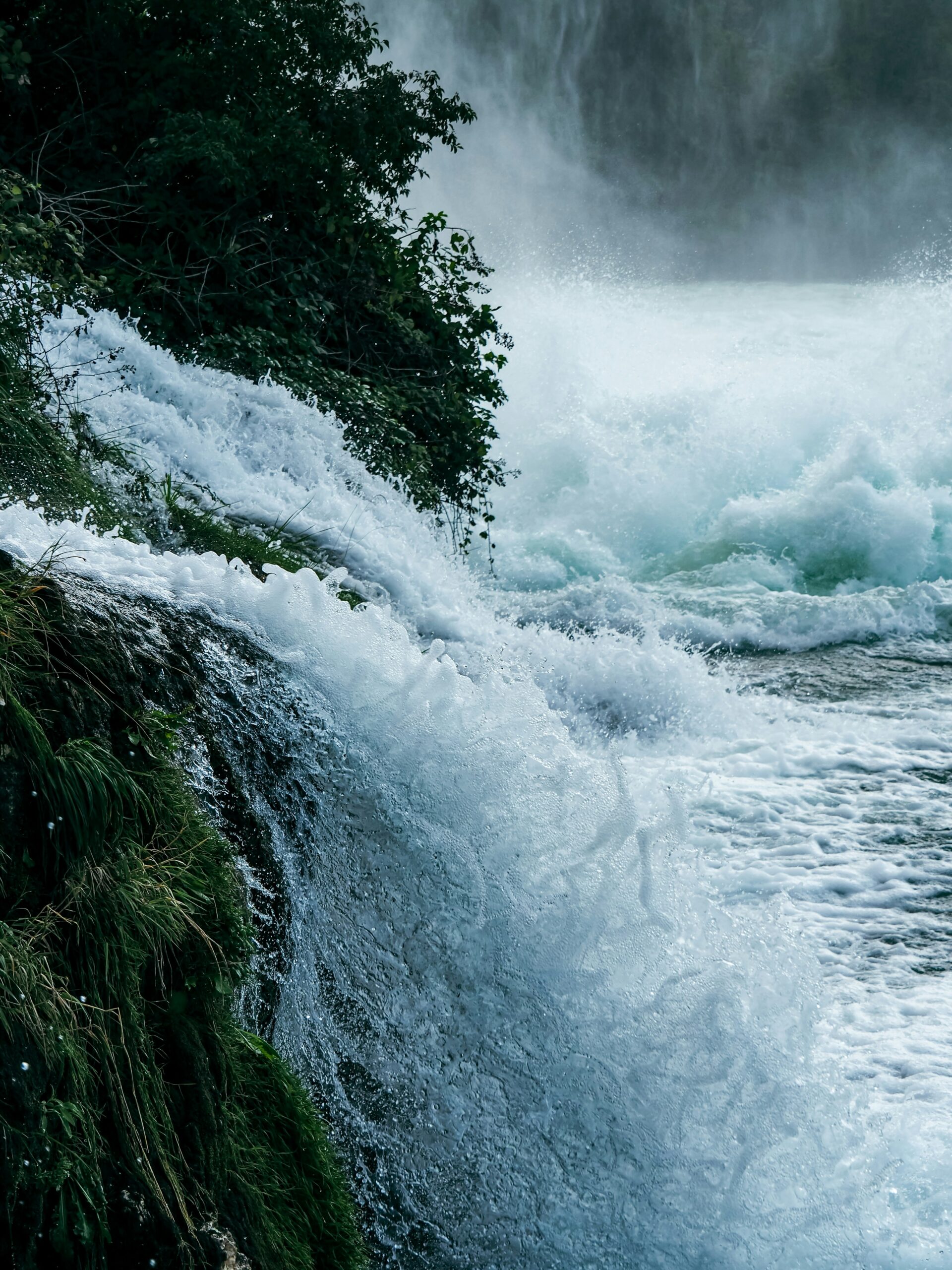 Photo of waterfall spurting water into a larger body of water.